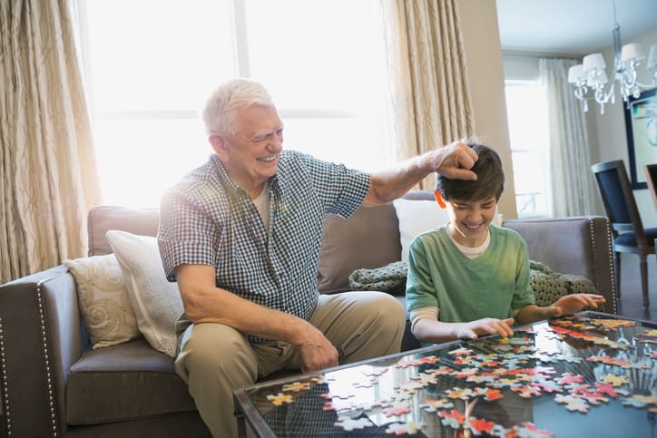 TLC Your Way Home Care Services | York County, Marion County, Florence / Darlington County | playful grandfather and grandson solving puzzle at home
